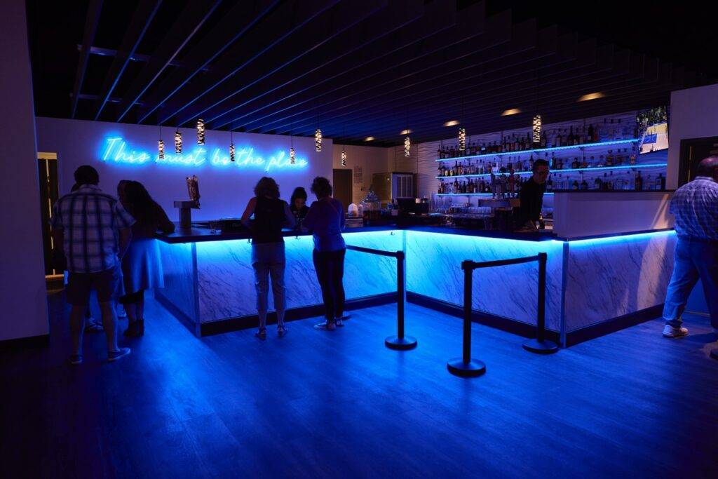 Guests at the blue-lit bar at Nissi’s