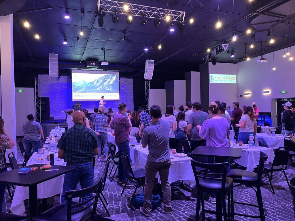Guests standing around tables during a company presentation at Nissi’s