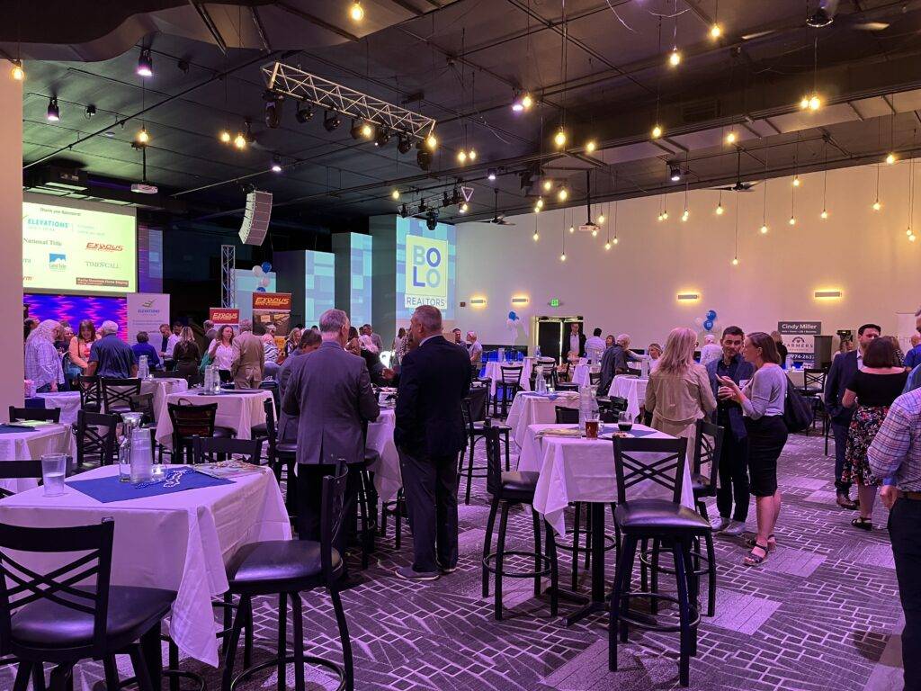 Guests networking around tables during a business event at Nissi’s