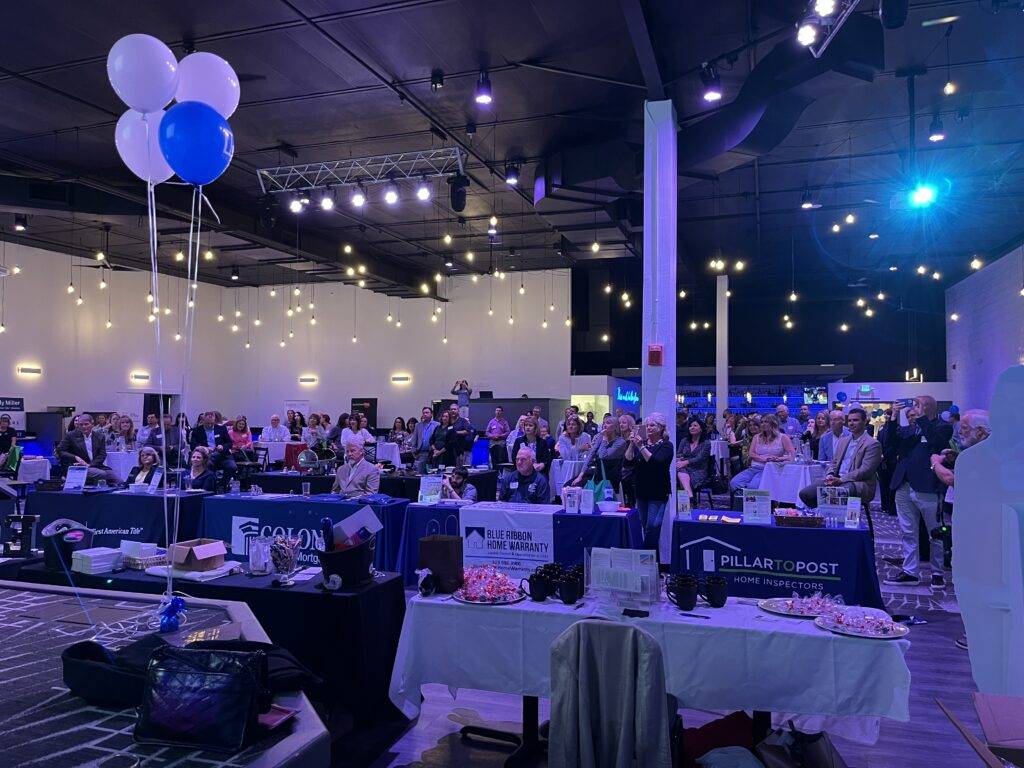 Guests gathered around display tables at a business event at Nissi’s