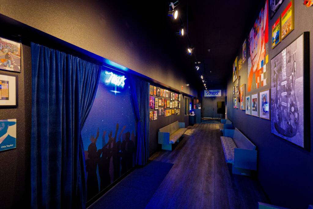Hallway with blue curtains and framed artwork at Nissi’s