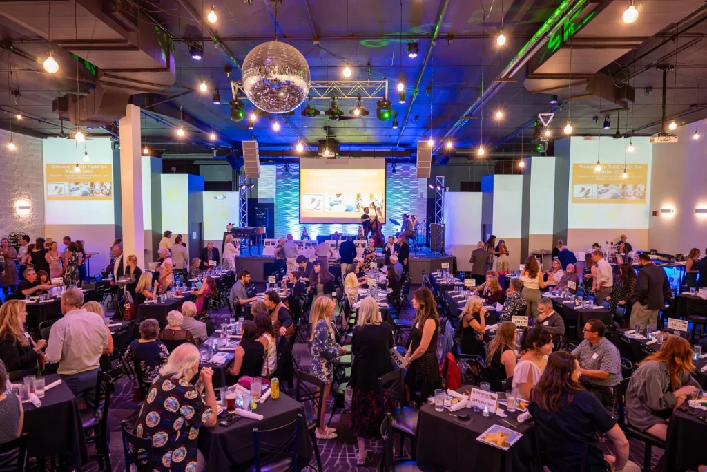 Guests dining and talking at tables in Nissi’s event room
