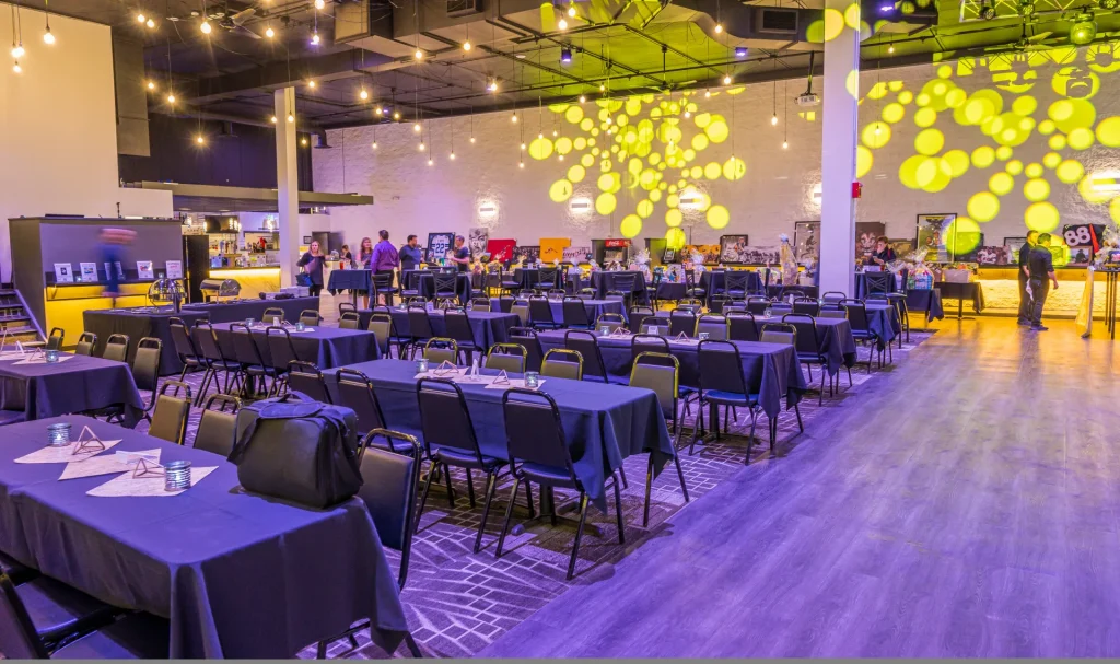 Nissi’s event room arranged with tables under yellow patterned lighting