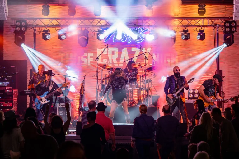 Live band performing beneath bright stage lights at Nissi’s