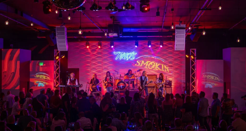 Live band performing on Nissi’s stage under red lighting