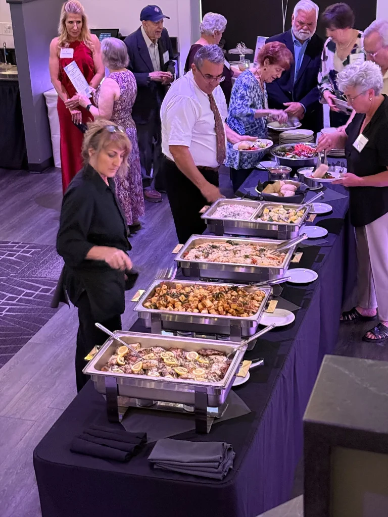 Guests being served at a catered buffet in Nissi’s event room
