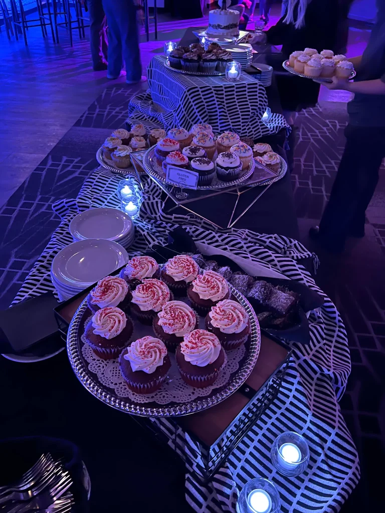 Cupcakes, cake and desserts arranged on an event table at Nissi’s