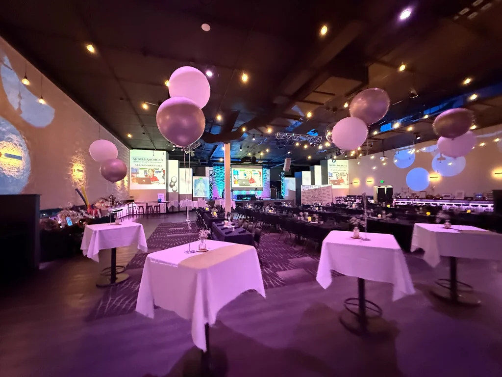 Tables and balloon decorations arranged for a fundraiser at Nissi’s