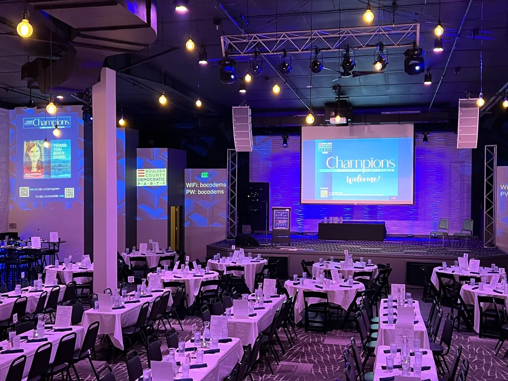 Tables facing Nissi’s stage and fundraiser projection screens