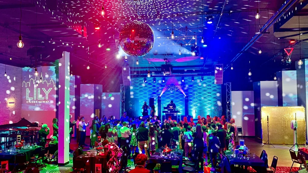 Mitzvah guests celebrating beneath patterned lights and a disco ball at Nissi’s
