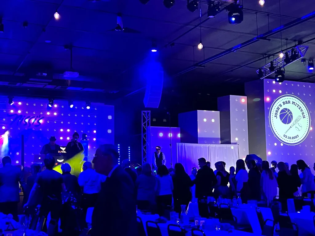 Guests on the dance floor under blue lighting during a mitzvah at Nissi’s